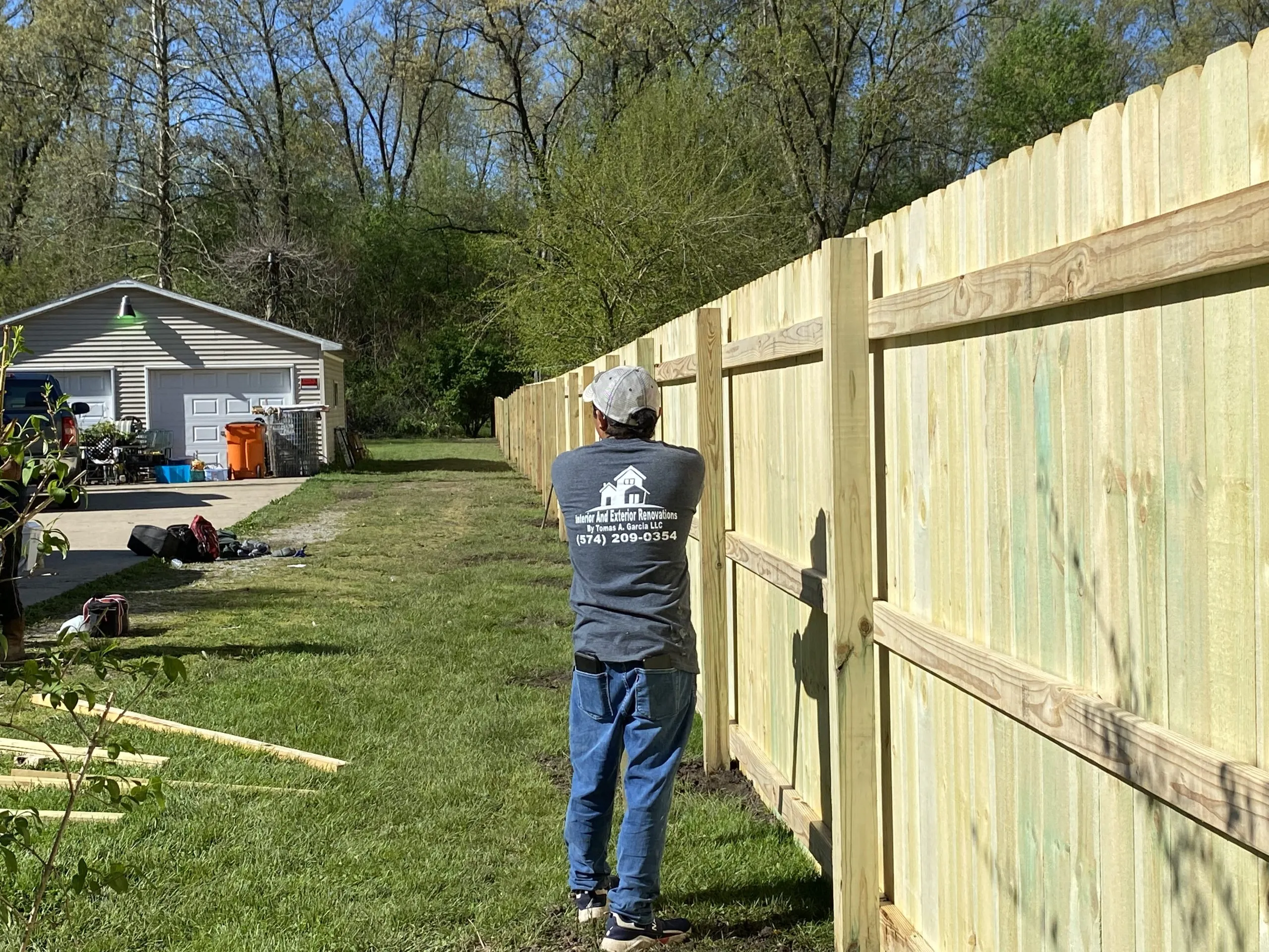 TG Renovates crew member finishing a cedar fence installation